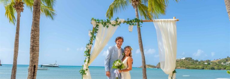 Couple beneath a beach ceremony arch, Carlisle Bay Antigua