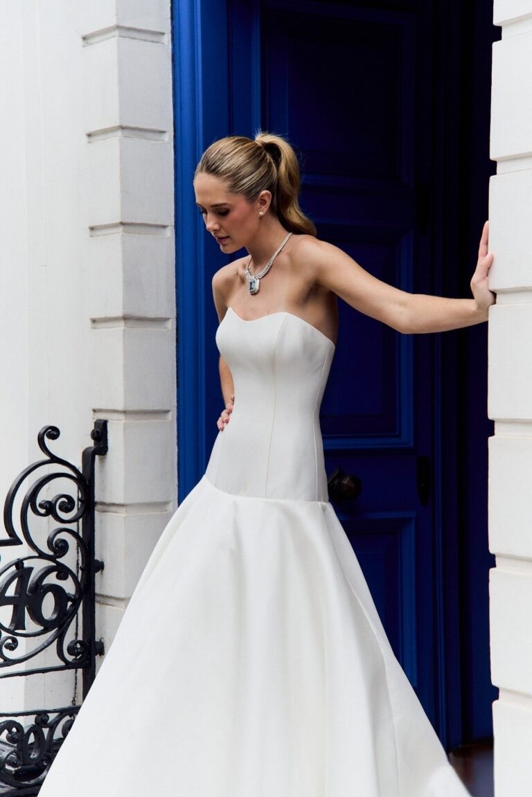 The Gardenia Bloom gown beside a blue door, Fleur d'Amour collection, Caroline Castigliano
