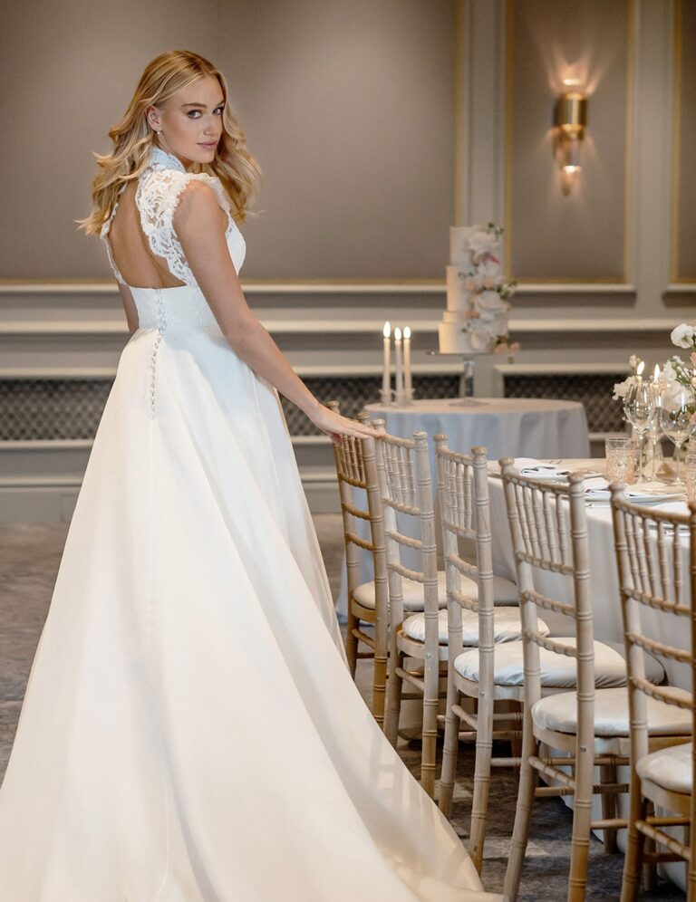 The Grace gown from the Icon collection beside a reception table, Caroline Castigliano