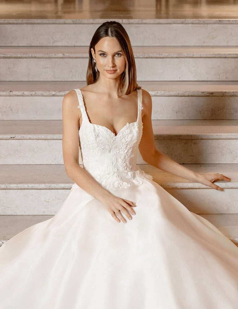 The Kensington gown from the Icon collection on a stone staircase, Caroline Castigliano