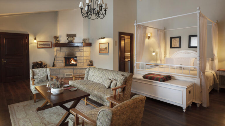 A guest room with a canopy bed and fireplace sitting area, Casa Lavanda