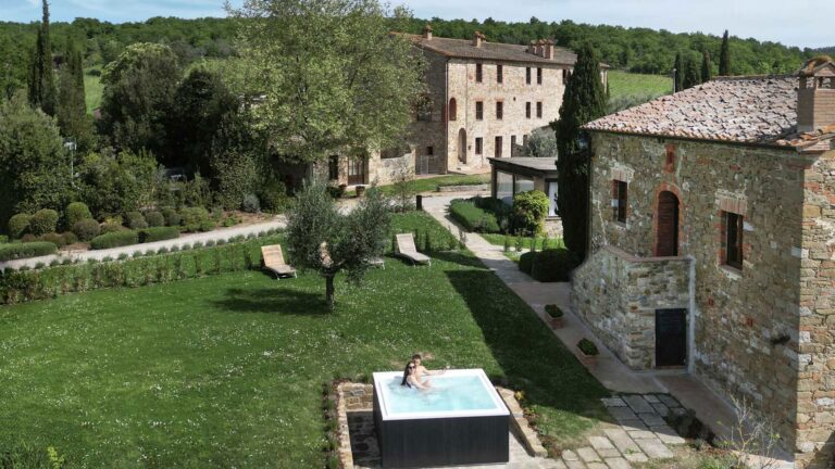 Garden and village buildings with a hot tub, Castel Monastero