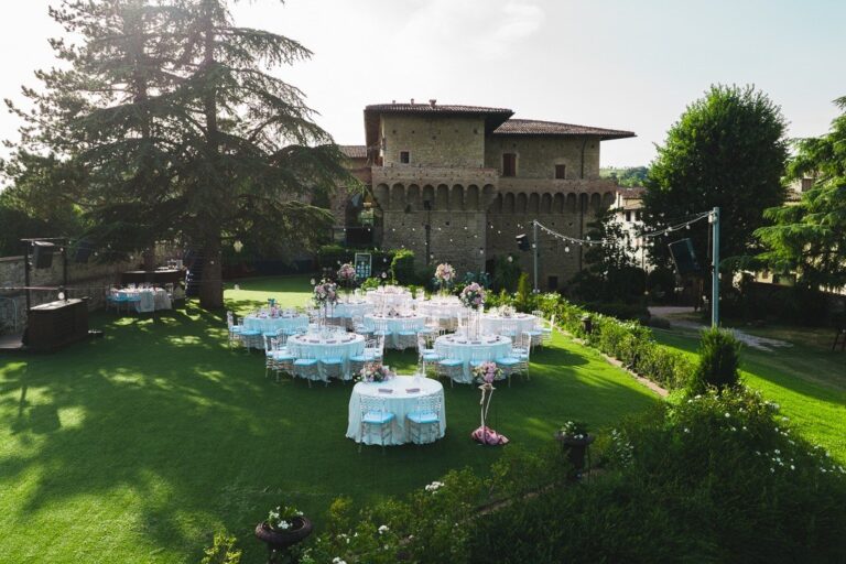 Round tables laid for dinner on the lawn in front of the castle, Castello del Capitano delle Artiglierie
