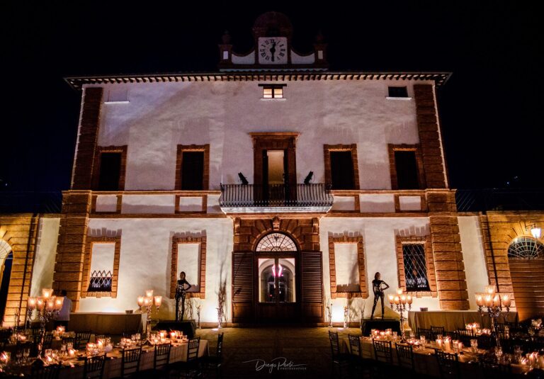 Castle facade lit at night, candlelit reception tables on the terrace, Castello di Solfagnano