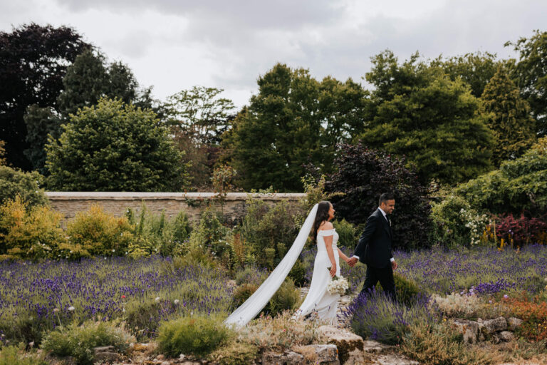A couple walking through the lavender in the walled garden, seen from a distance, Caswell House