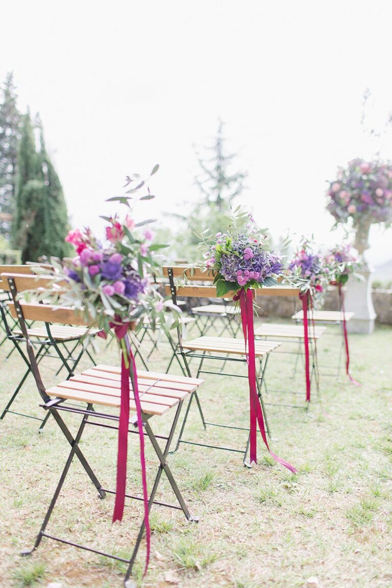 Aisle chairs tied with ribbons and flowers, Caterina Weddings