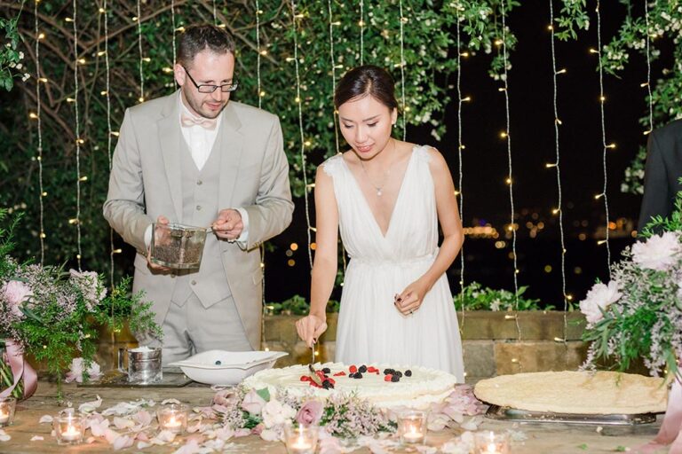 The couple cutting a berry tart at an evening reception, Caterina Weddings