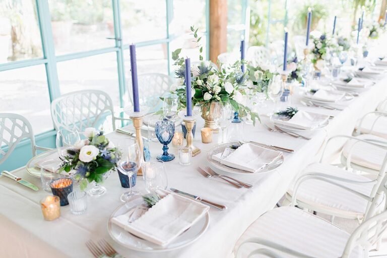 Long table with blue candles and white flowers, Caterina Weddings