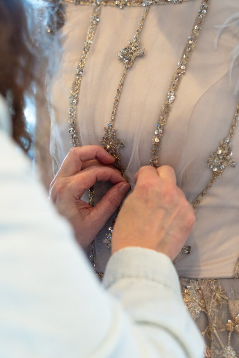 Hands attaching beaded embellishment to a couture bodice, Catherine Blades Couture