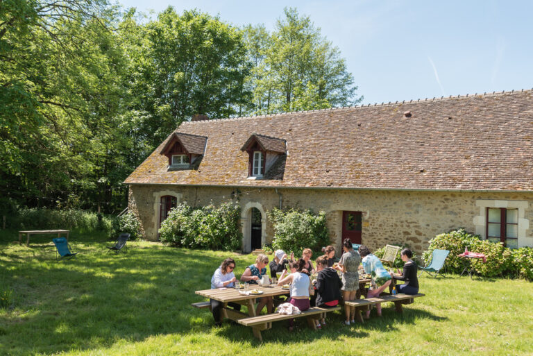 Guests at a long table on the lawn by a gite, Château de Chéronne