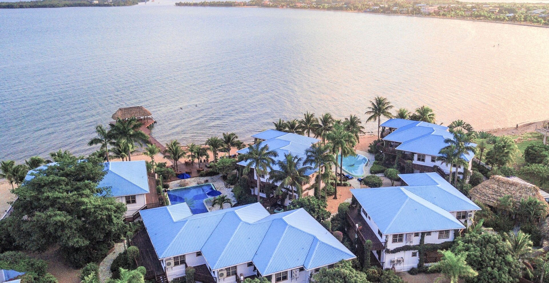 An aerial of the resort and its blue-roofed villas seen from over the sea, Chabil Mar Resort