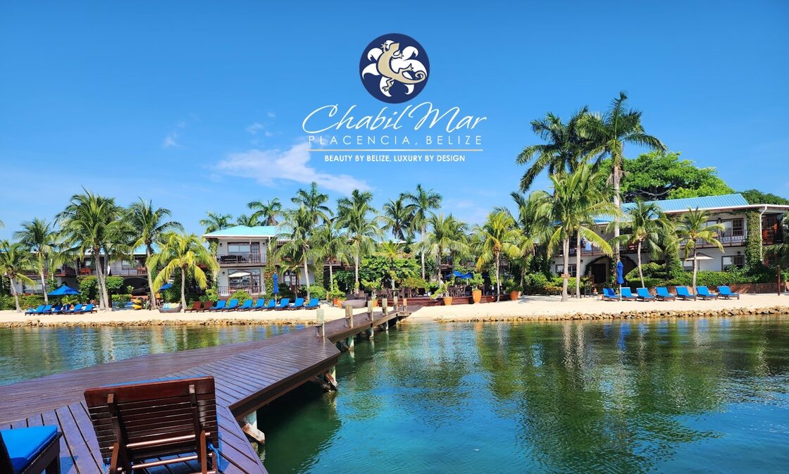 An aerial along the private pier, over turquoise water toward the villas, Chabil Mar Resort