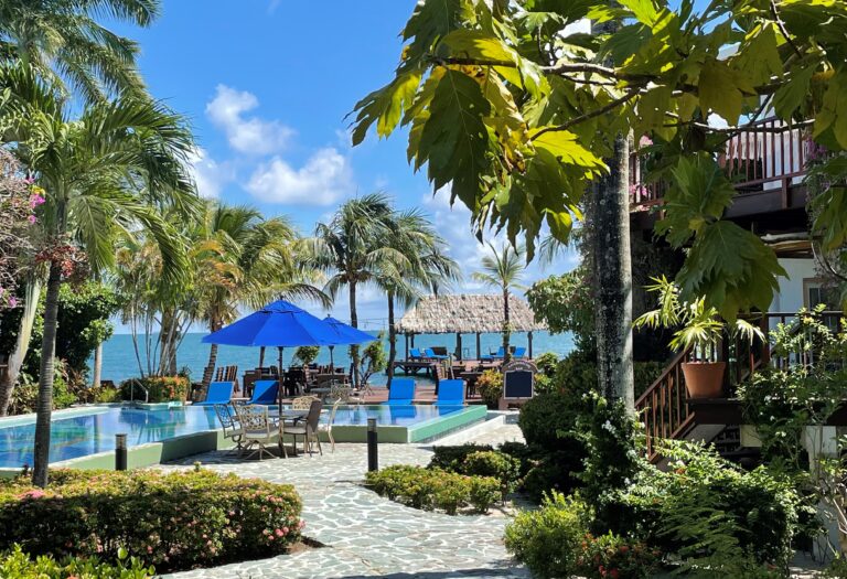 A pool and lush gardens with loungers and villas beyond, Chabil Mar Resort