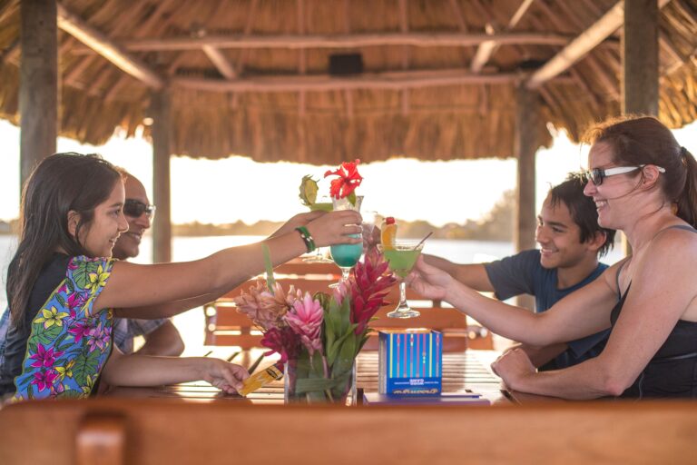 Guests toasting cocktails at the palapa beach bar, Chabil Mar Resort