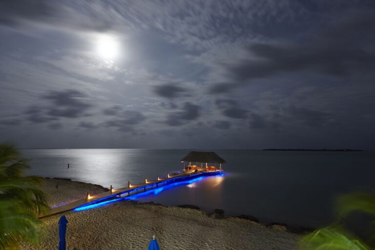 The pier beneath a full moon at night, lights along the deck, Chabil Mar Resort