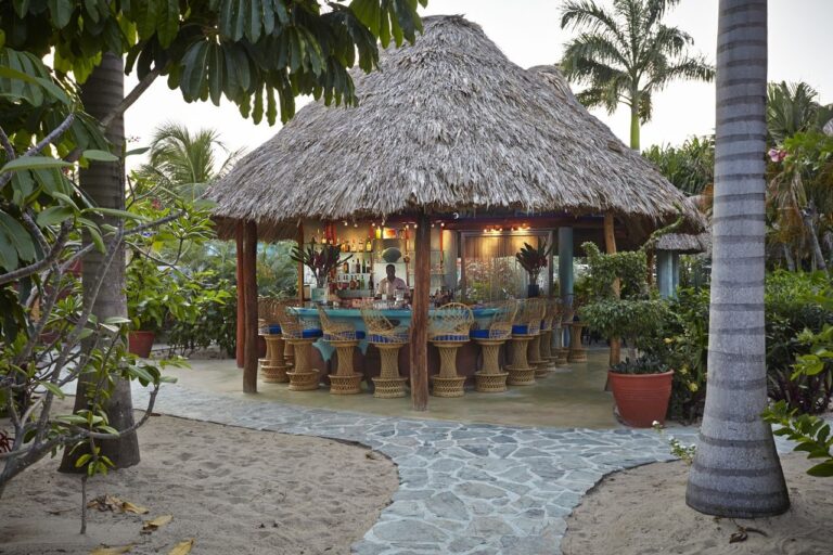 The thatched palapa beach bar at dusk on the sand, Chabil Mar Resort