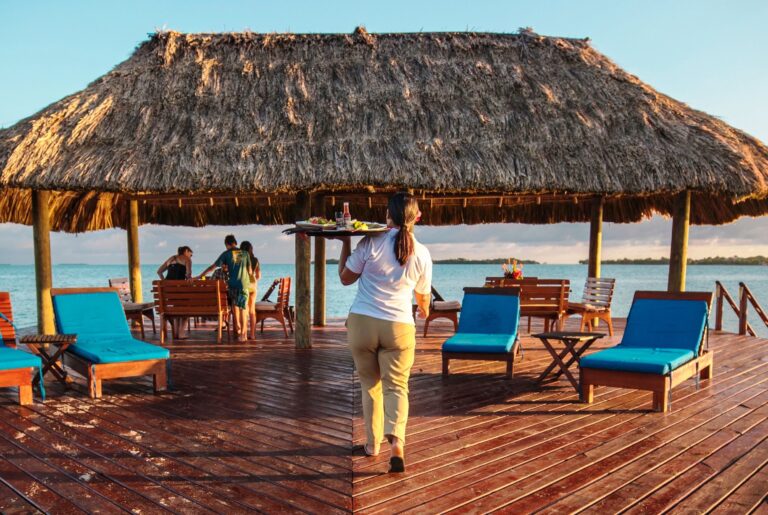The palapa pier bar and deck with turquoise loungers over the water, Chabil Mar Resort