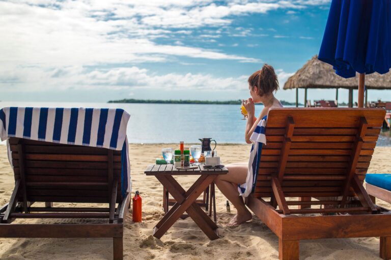 Guests relaxing in beach chairs on the sand by the sea, Chabil Mar Resort