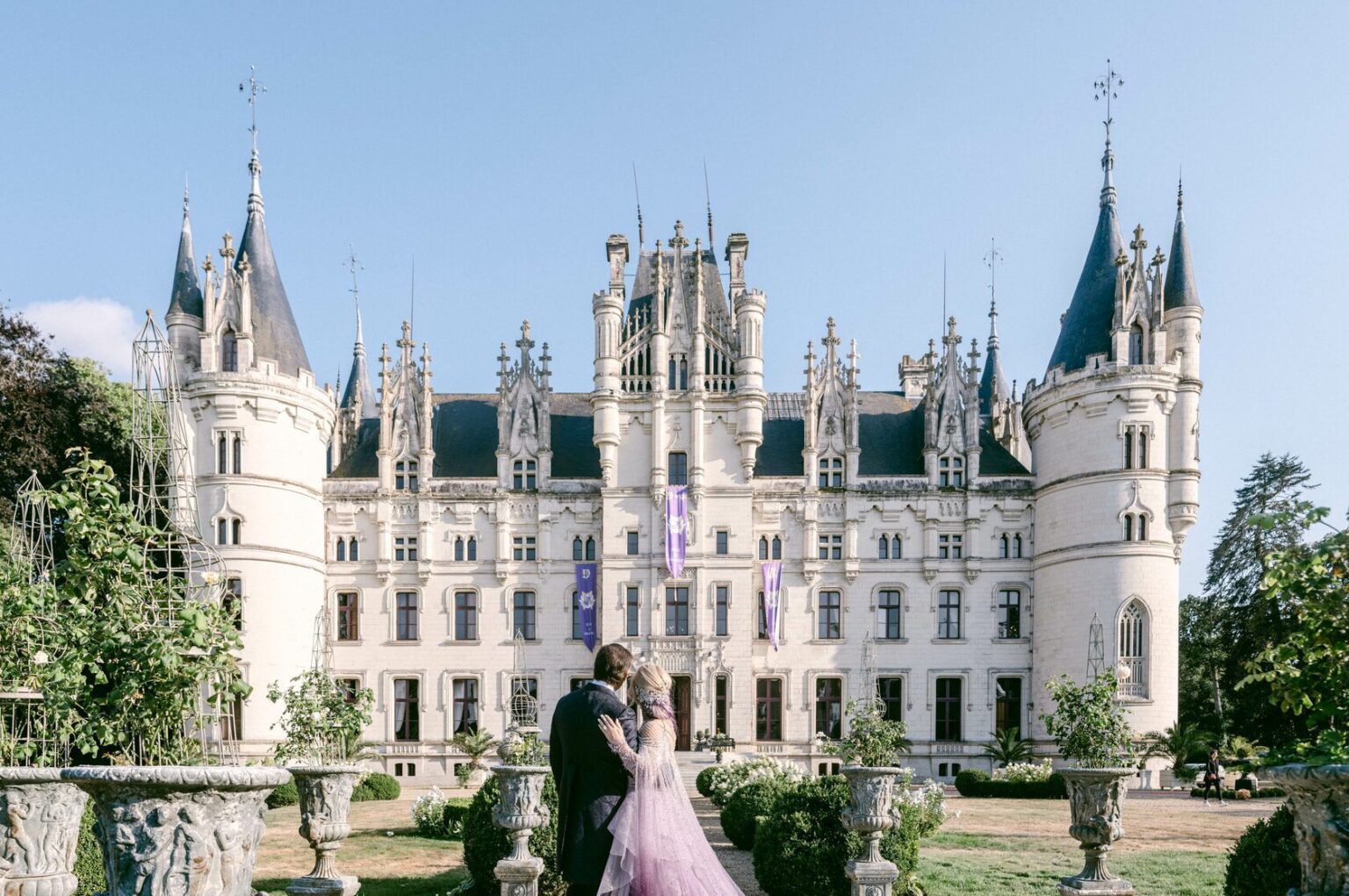 The chateau front with a couple on the garden terrace