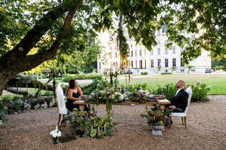 Couple at a table beneath the garden trees, Chateau Challain