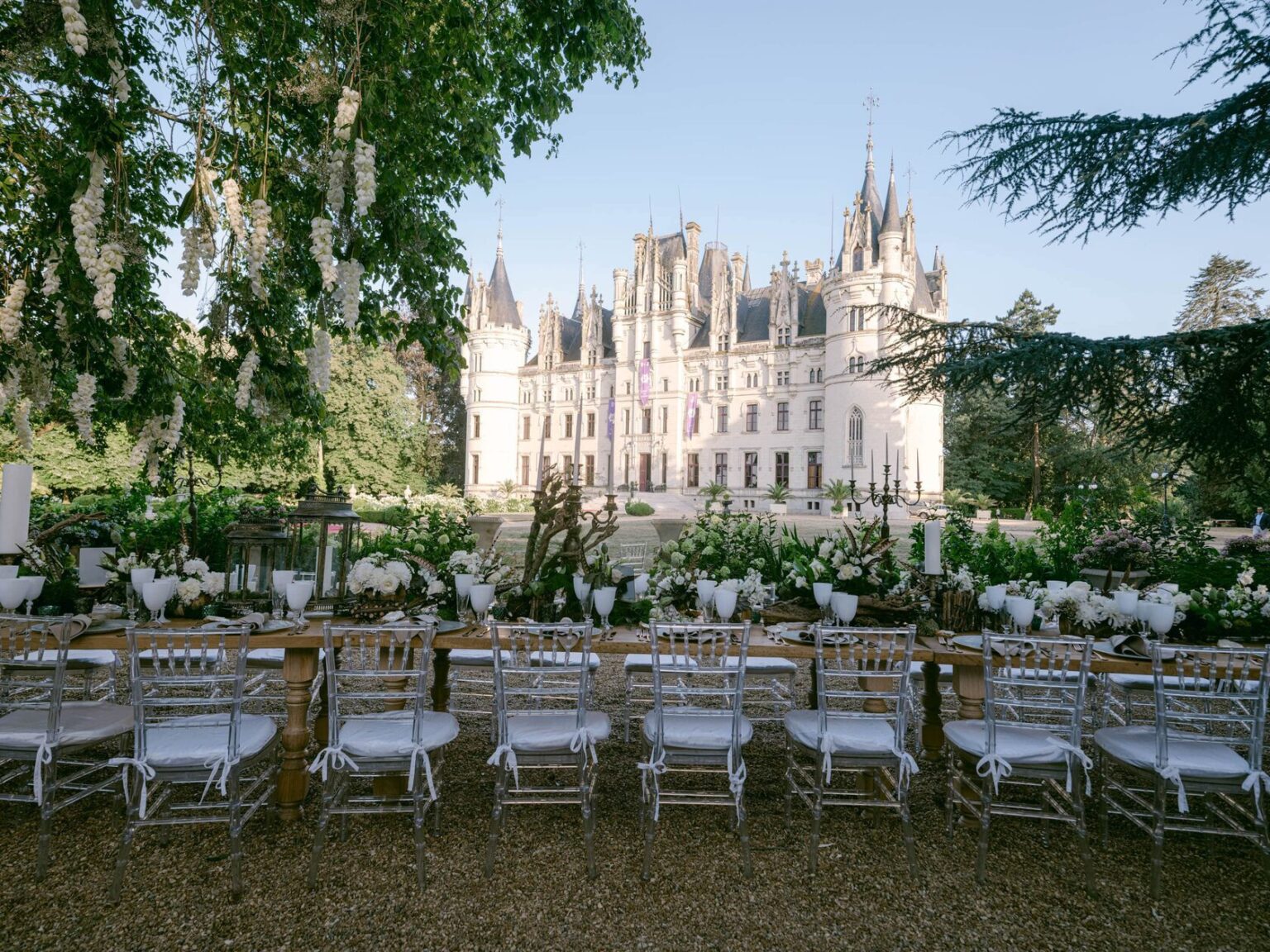 Long reception tables set on the lawn before the chateau