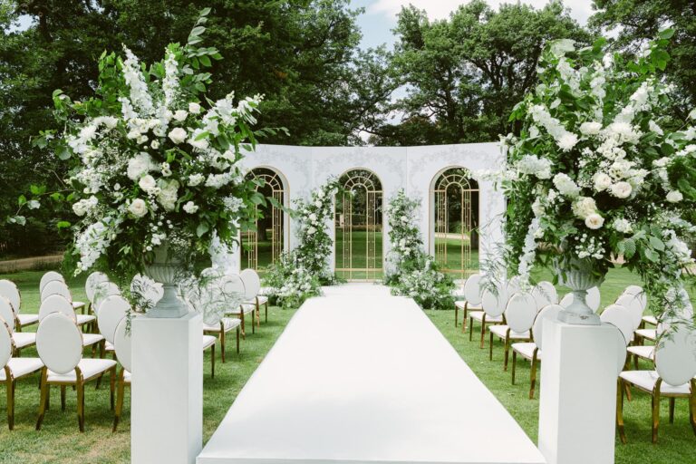 A ceremony aisle framed by white flowers in the park, Chateau Mcely