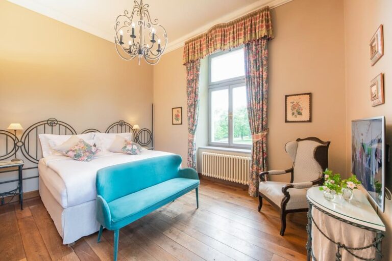 A room with a turquoise bench at the foot of the bed, Chateau Mcely