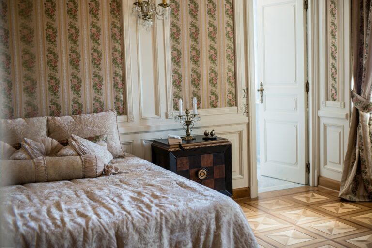 A bedroom with a quilted bed and parquet floor, Chateau Saint Georges