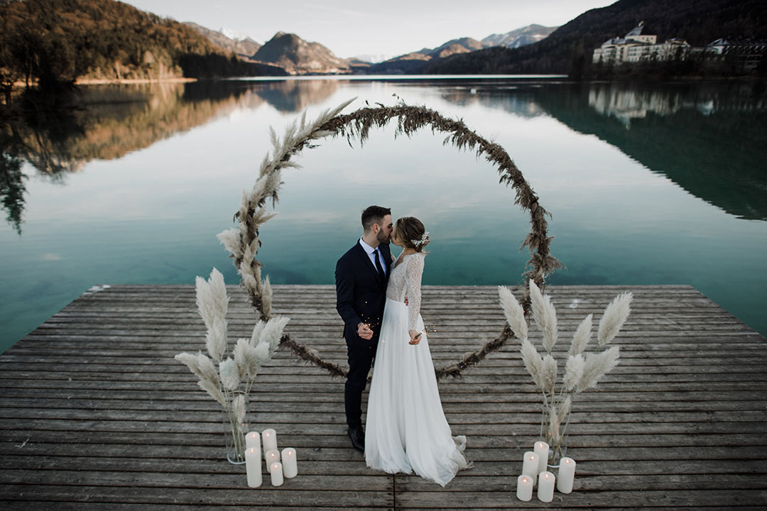 Couple embracing beneath a ring arch on a jetty at a mountain lake, Cherry On Top