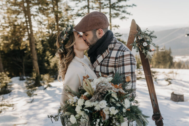 Couple kissing in the snow with skis and a winter bouquet, Cherry On Top
