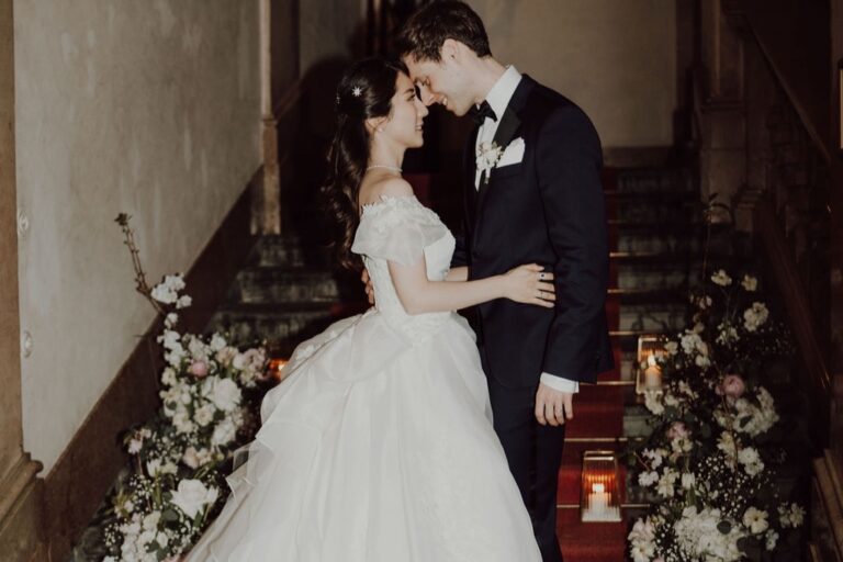 Couple embracing on a staircase dressed with flowers and candles, Cherry On Top