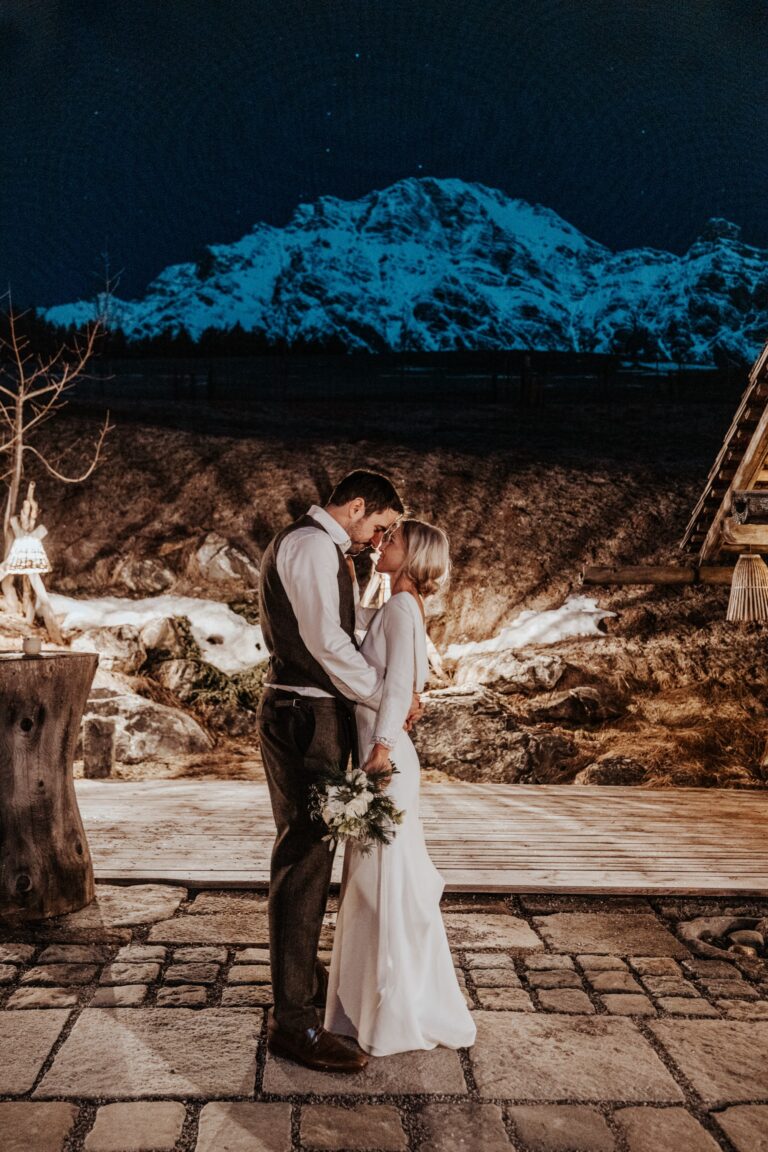 Couple at night on a stone terrace with a lit mountain behind, Cherry On Top