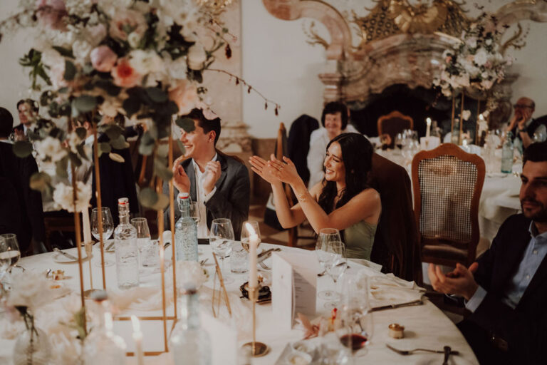 Guests at a candlelit round table with tall gold stands and florals in a historic dining room, Cherry On Top