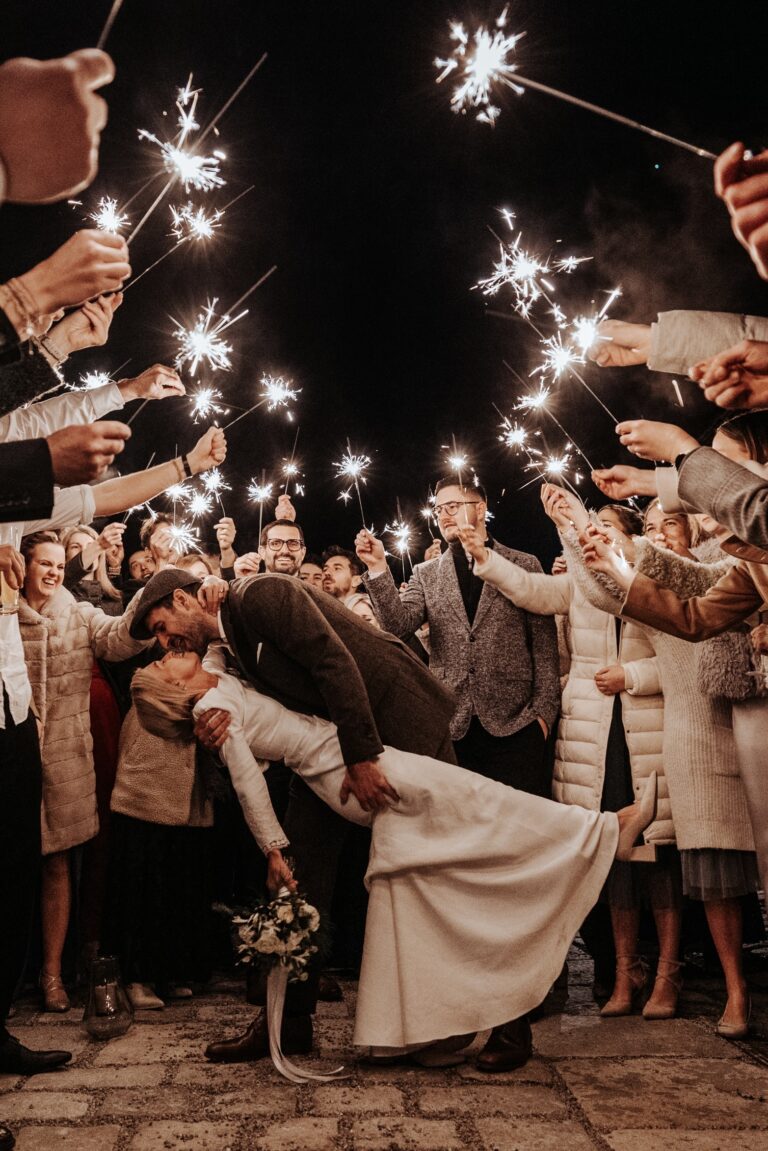 Guests forming a sparkler tunnel for the couple at night, Cherry On Top