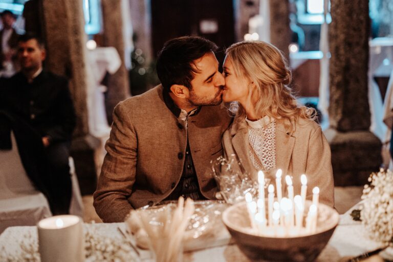 Couple in Tracht kissing at a candlelit table, Cherry On Top