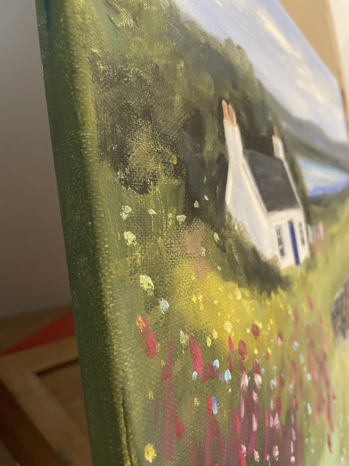 Painting: a white cottage on the edge of a canvas