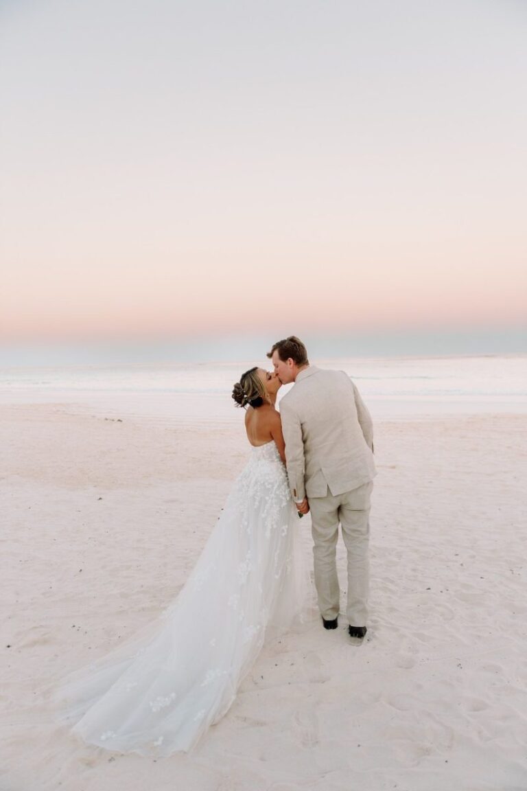 Couple kissing on a pale beach at sunset, Chic Bahamas Weddings