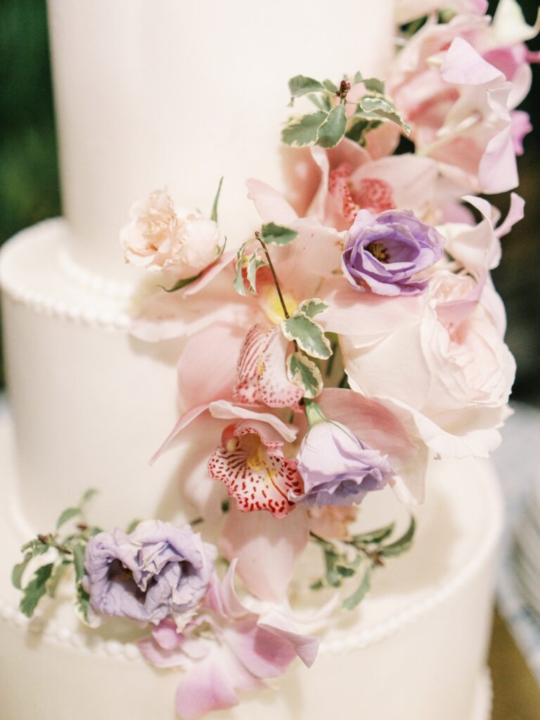 White wedding cake decorated with pink and lilac orchids, Chic Bahamas Weddings