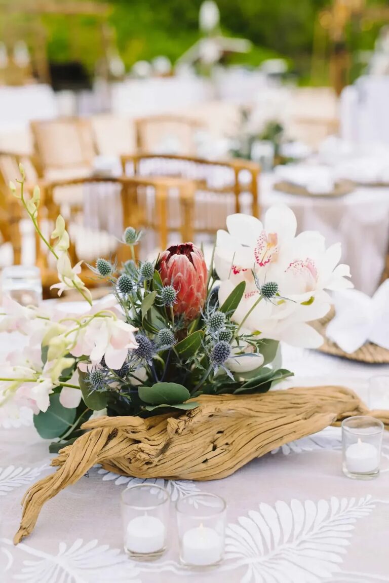 Driftwood centrepiece with protea and orchids on a patterned tablecloth, Chic Bahamas Weddings