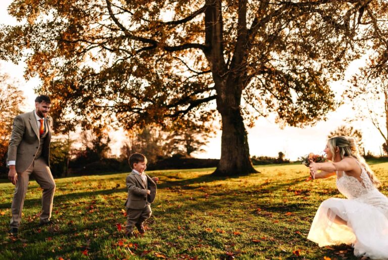 A family moment beneath a great tree in the grounds at golden hour in autumn, Clearwell Castle