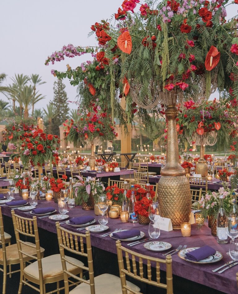 Tall red floral centrepiece above a long reception table, Cocoon Events