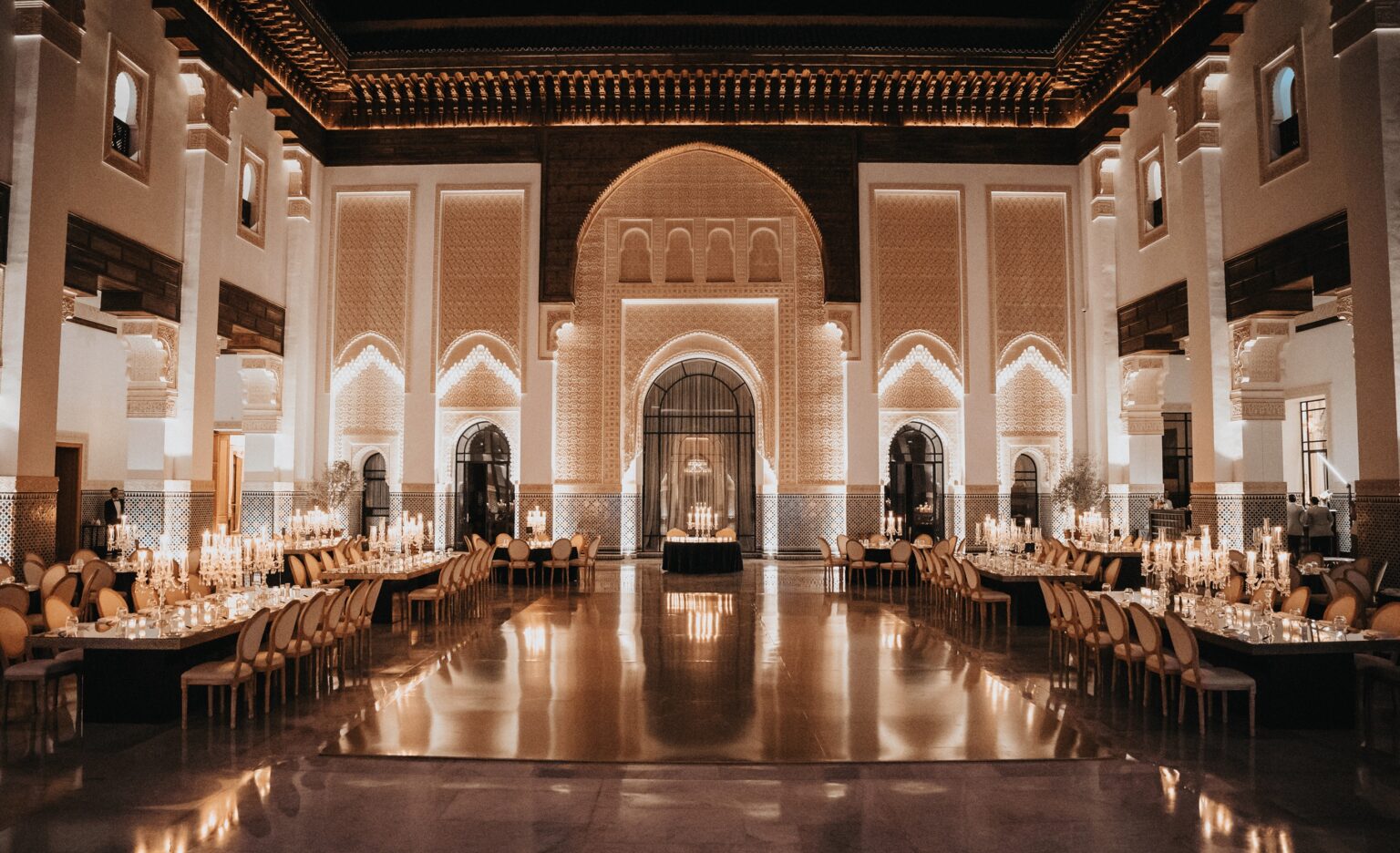 Long candlelit reception tables in a palace hall