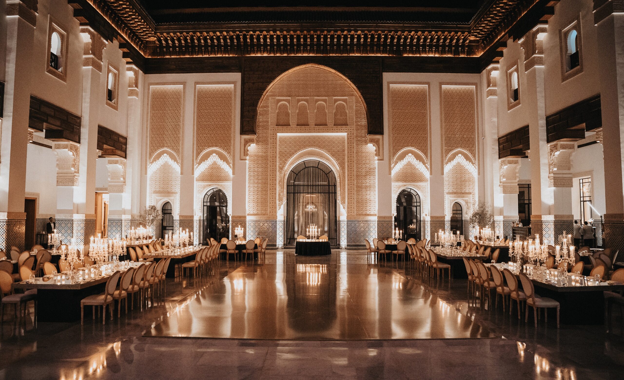 Long candlelit reception tables in a palace hall, Cocoon Events