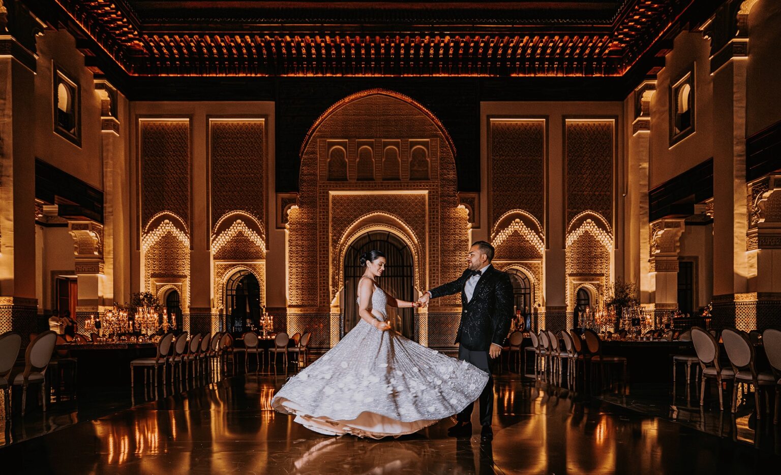 The bride and groom dancing in an ornate illuminated hall