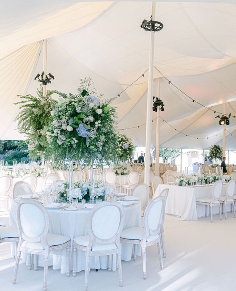 Marquee interior with white tables and floral centrepieces, Cocoon Events