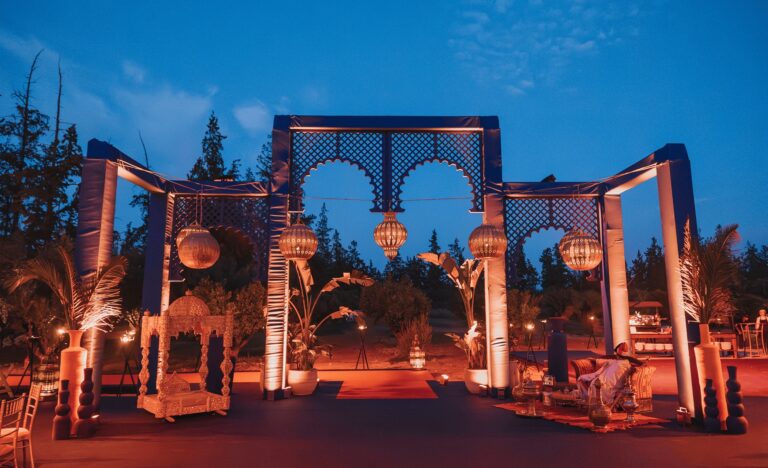 Moroccan-style arched structures lit at dusk in a garden, Cocoon Events