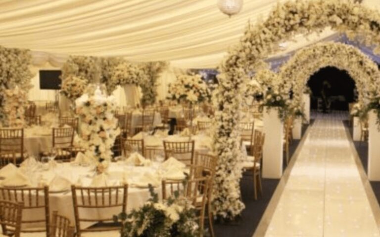 A floral arch and aisle between tables in the marquee, Coombe Abbey
