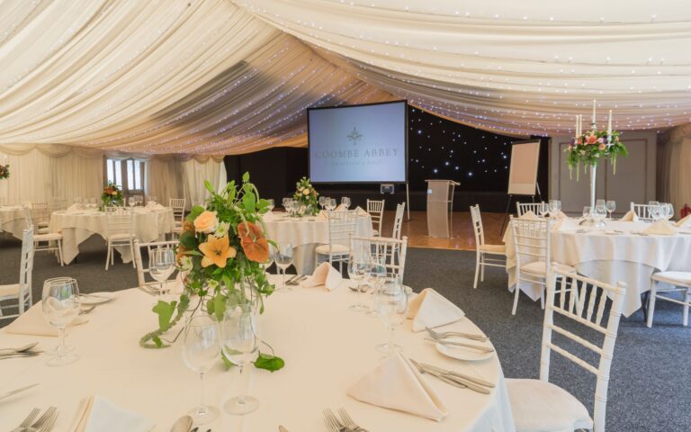Round tables with flower centrepieces in the marquee, Coombe Abbey