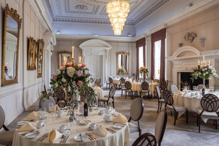 A white reception room set with round tables, Coombe Abbey