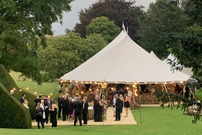A white marquee with guests gathered outside, Cornwell Manor